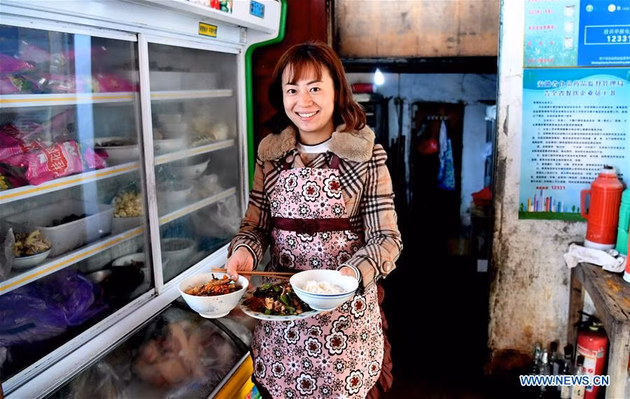Trong ảnh là Qing Ningling, chủ một quán trọ địa phương, đang chuẩn bị đồ ăn trưa sau khi nhận khách du lịch ở khu phố Yuehua hôm 6/2. Ảnh: THX.