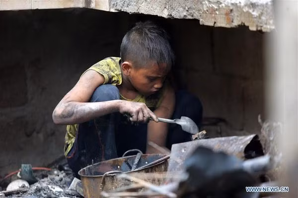 Một bé trai tìm kiếm những vật dụng còn sử dụng sau vụ cháy hôm 8/2. Ảnh: THX.