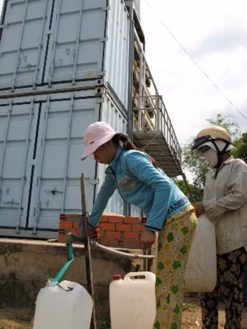 Người dân đang chắt chiu từng giọt nước ngọt mua với giá đắt đỏ. Ảnh: Báo Ngày nay.