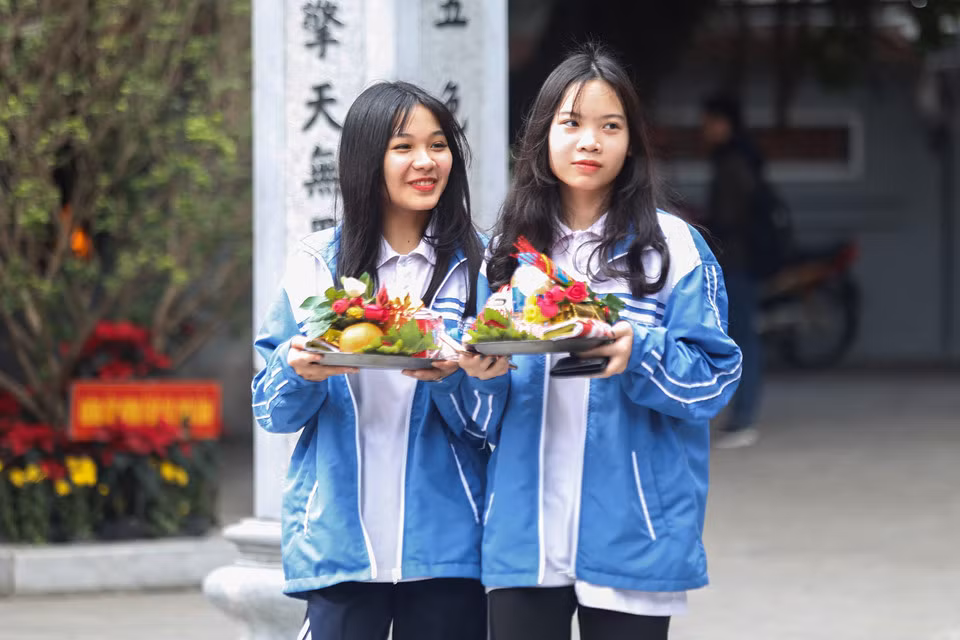 Nhiều em học sinh trong chiếc áo đồng phục cũng háo hức sắp lễ đi chùa.