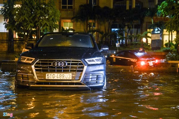 Một chiếc Audi nằm bất động giữa dòng nước gần 4 giờ. Anh Trường, chủ nhân chiếc xe chia sẻ sóng nước lớn đã khiến xe của anh quay đầu, nằm ngang giữa đường.