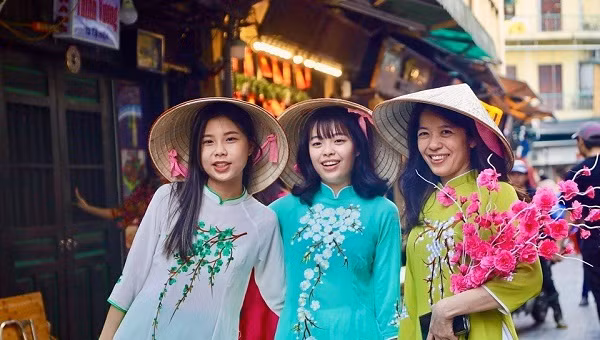 Năm nay, những chiếc áo dài cổ điển kết hợp các phụ kiện như khăn choàng, guốc mộc, kính mắt hay chiếc quạt cầm tay vừa mang nét đẹp cổ điển vừa hiện đại. Áo dài các gam màu đỏ, hồng, vàng là lựa chọn của nhiều bạn nữ với mong muốn đón nhận may mắn, nhiều điều tốt lành trong học tập, công việc dịp năm mới Giáp Thìn 2024. Cùng ngắm sắc Xuân qua trang phục áo dài truyền thống của các cô gái trẻ: Các bạn trẻ lựa chọn áo dài truyền thống hoặc cách tân với nhiều màu sắc khác nhau. (Nguồn: KT&amp;ĐT)