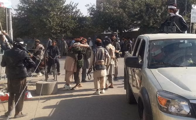 Các chiến binh Taliban ôm nhau vui mừng sau khi chiếm được thành phố chiến lược của Afghanistan.