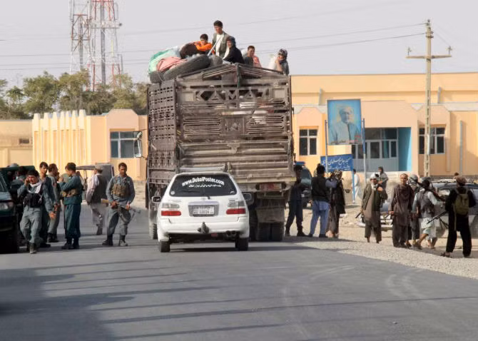 Người dân Afghanistan ngồi trên một chiếc xe tải và sơ tán đến nơi khác khi lực lượng Taliban chiếm giữ thành phố Kunduz.