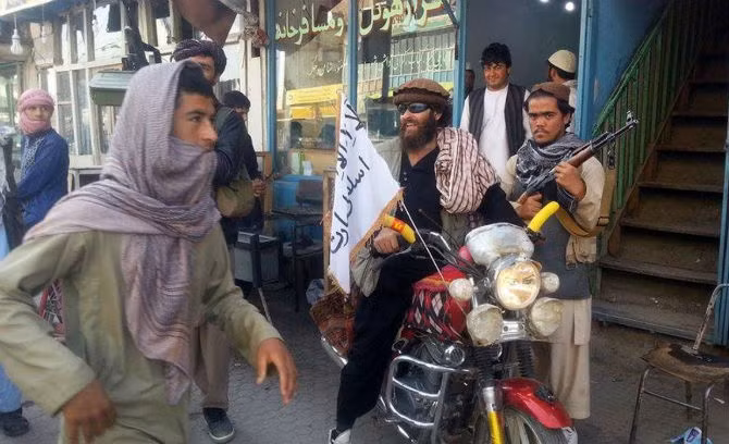 Một chiến binh Taliban ngồi trên chiếc xe máy treo cờ của nhóm này trên một con đường ở thành phố Kunduz ngày 29/9.