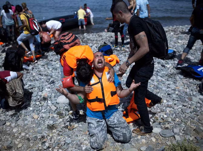 Một người tị nạn Syria cầu nguyện khi tới được đảo Lesbos, Hy Lạp, sau chuyến hành trình qua biển Aegean từ Thổ Nhĩ Kỳ ngày 7/9. Trong năm 2015, hơn 230 nghìn người đã đặt chân đến Hy Lạp và số người nhập cư tăng mạnh trong những tuần gần đây.