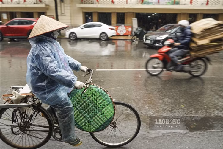 Dưới cái lạnh như cắt da thịt ở Hà Nội, nhiều người lao động nghèo vẫn lặng lẽ mưu sinh. (Ảnh: Lao Động).