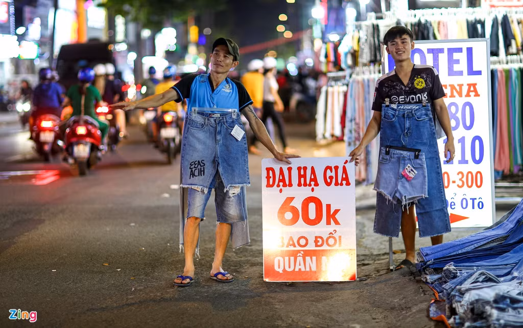 Nhân viên các gian hàng trên vỉa hè liên tục vẫy tay mời chào khách nhưng thỉnh thoảng mới có vài khách ghé xem rồi dời đi.