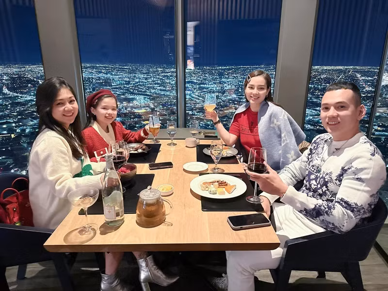 Vợ chồng Lý Bình cùng con gái ăn tối trên tòa nhà cao tầng.