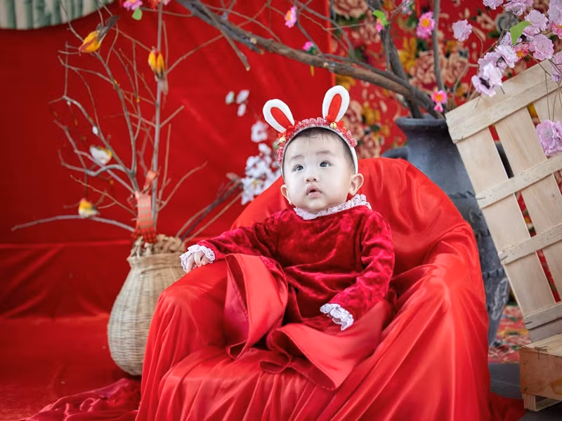Bé Vừng - con gái của Vân Hugo diện áo dài đỏ.