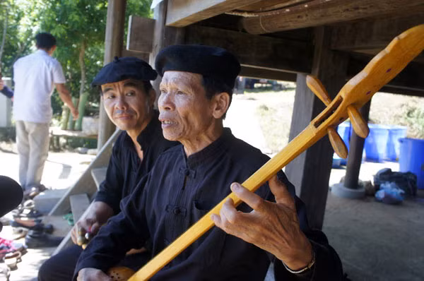 Trong lúc chuẩn bị lễ, các nghệ nhân ở dưới nhà hát then chào đón khách.