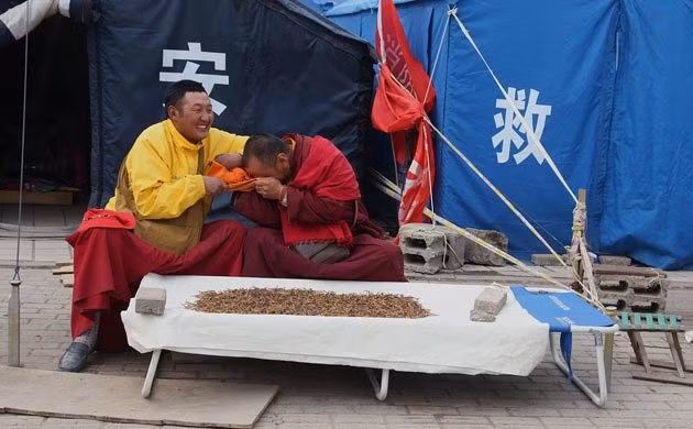 Hai nhà sư trêu đùa nhau khi bán đông trùng hạ thảo bên ngoài lều tạm của họ.