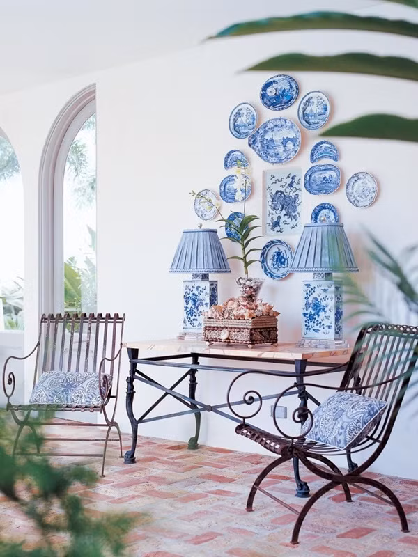 Sự kết hợp thú vị giữa kiến trúc Tây Phương và Châu Á với sắc xanh da trời cổ điển trên những họa tiết gốm sứ treo trên tường và gối ôm trên ghế ngồi kiểu cách.