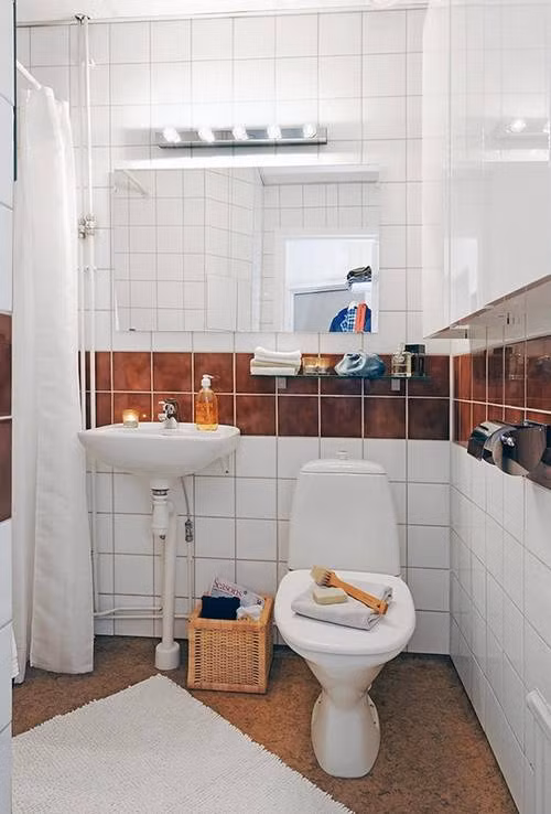 Còn phòng tắm, kệ tường cũng được tận dụng tối đa để giữ đồ đạc thiết yếu.