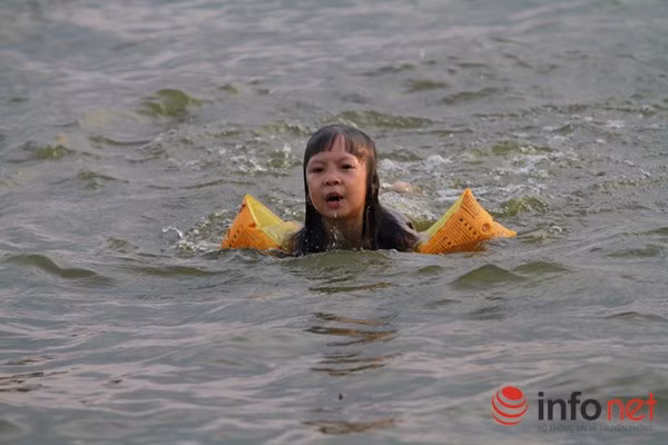 Một số em nhỏ được bố mẹ trang bị đầy đủ những chiếc phao bơi.