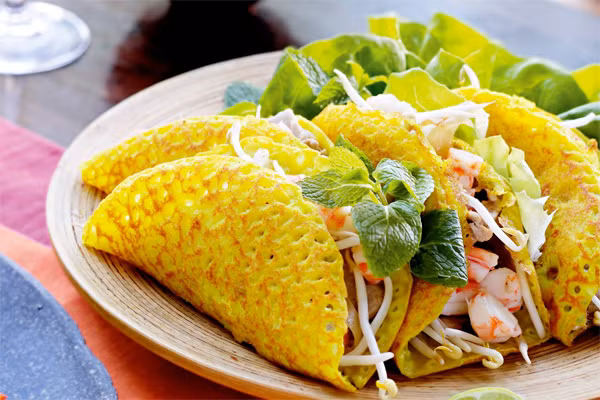 Món bánh mỏng, giòn, vàng ruộm với nhân tôm thịt, giá đỗ và các loại rau thơm ăn kèm nước chấm chua ngọt ngon tuyệt. Bánh chỉ được làm khi có khách gọi món.
