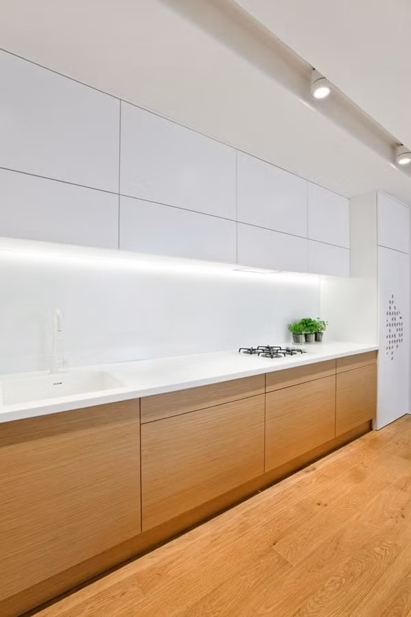 Góc bếp bài trí nội thất đơn giản từ màu sắc đến kiểu dáng, ánh sáng trắng hỗ trợ không gian, giúp căn phòng rộng hơn nhiều so với diện tích thực.