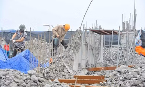 Công nhân tiến hành khoan, phá dỡ phần công trình xây dựng trái phép ở toà nhà số 8B Lê Trưc, Hà Nội, sáng 6/3. (Ảnh: Minh Đức/TTXVN)