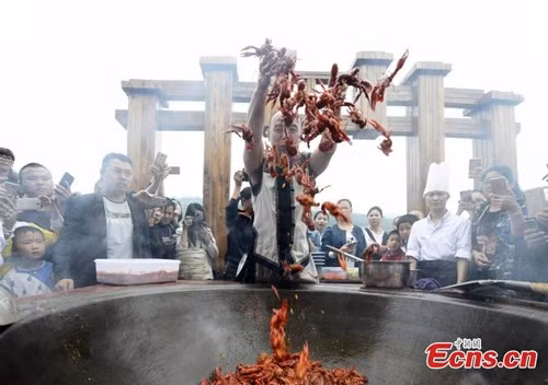 Tại đây, đầu bếp dị nhân Tang Chenggang đã biểu diễn màn xào tôm hùm đất bằng tay trần trong một chiếc chảo gang có đường kính lên tới 2m.