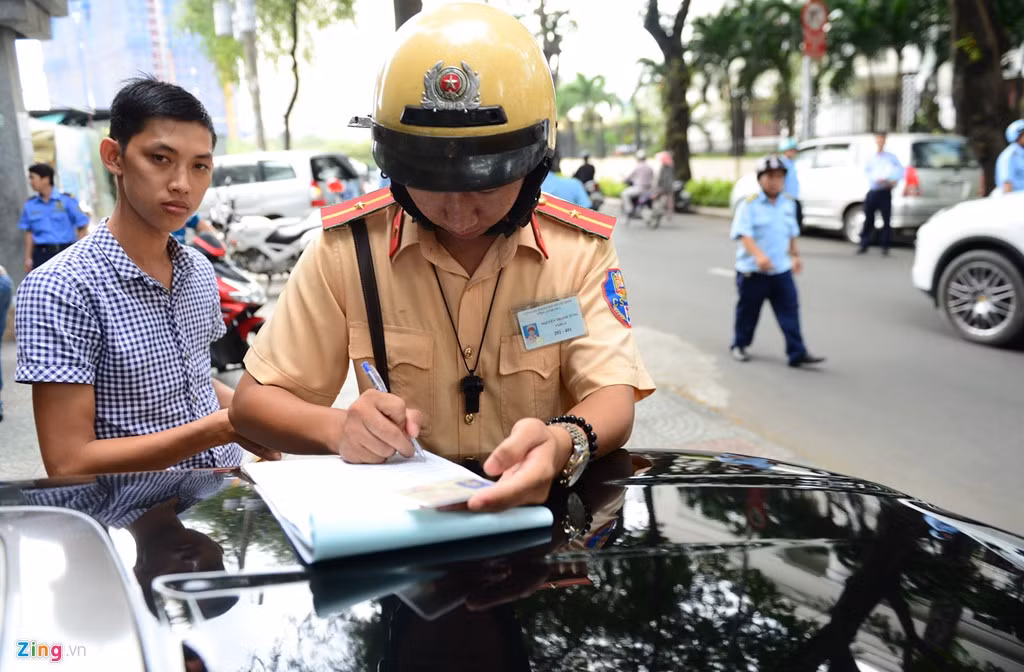 CSGT đang tiến hành lập biên bản xử phạt người điều khiển phương tiện đậu xe lấn chiếm vỉa hè.