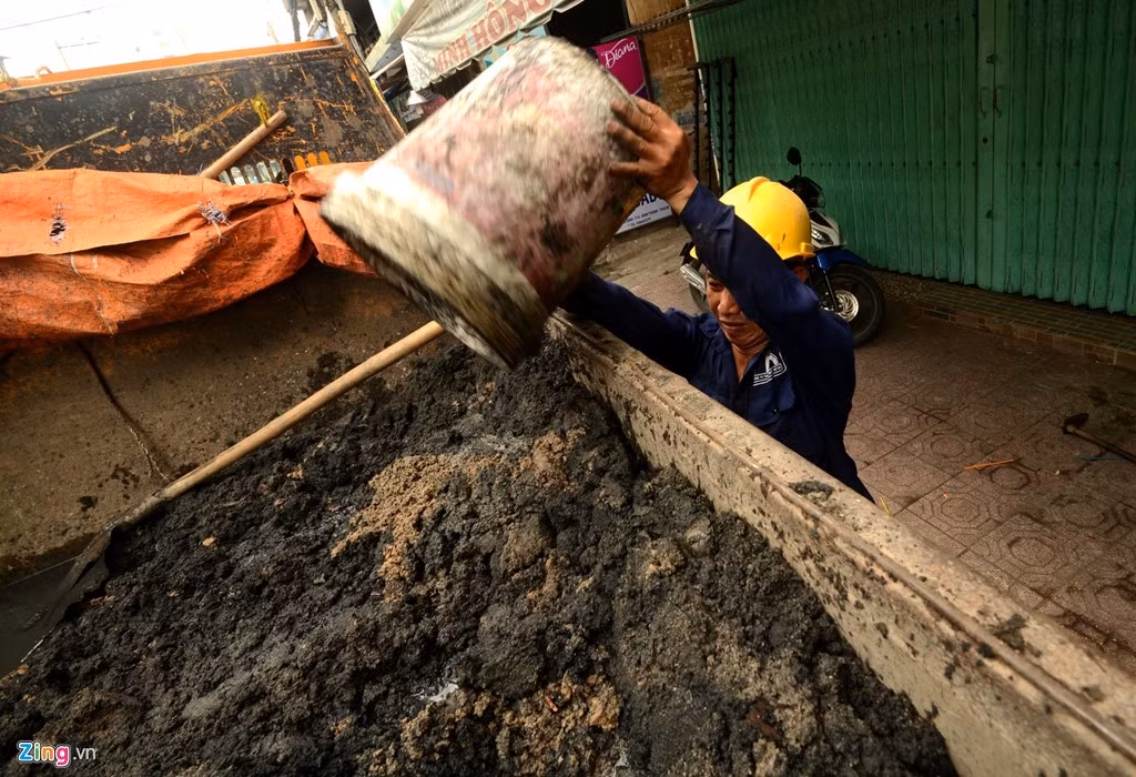Không chỉ lo thoát nước, các công nhân còn phải làm công việc vận chuyển bùn nặng nhọc lên xe chở đi ngoại thành xử lý.