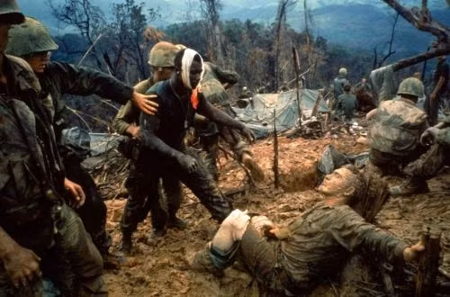 Trung sĩ hải quân Jeremiah Purdie (ở giữa, băng đầu) tiến tới chỗ một binh sĩ khác đang bị thương trong khi tham chiến tại một vùng phi quân sự ở miền Nam Việt Nam tháng 10/1966. (Ảnh: Larry Burrows - Time &amp; Life Pictures/Getty Images)