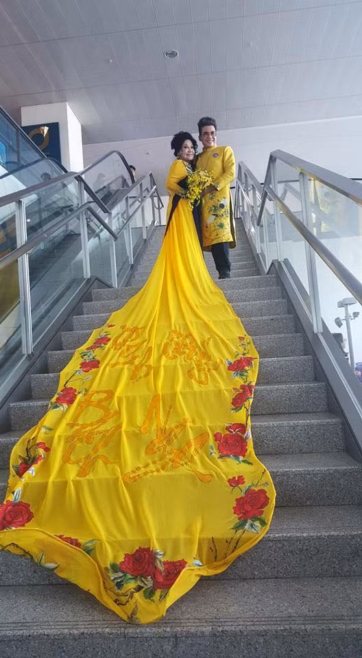 Nữ doanh nhân Thuý Nga diện áo dài với phần tà kéo dài 5 mét, thêu tên của cả hai.