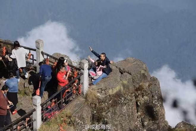 Có du khách Trung Quốc "khác người" còn đưa cả trẻ em ra đứng ở mỏm núi chênh vênh để có một tấm ảnh đẹp. (Nguồn: QQ News)