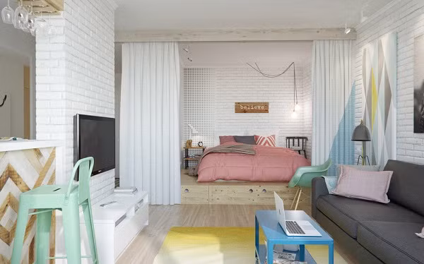 Khu vực nghỉ ngơi. Không gian dành cho việc ngủ nghỉ hàng ngày được 'khoanh vùng' bằng tấm rèm trắng khá dày tạo sự riêng tư cũng như độ mềm mại, thông thoáng cho căn hộ. Nơi nghỉ ngơi được nâng cấp sàn tạo sự tách biệt cũng như tăng thêm diện tích lưu trữ cho khu vực này.