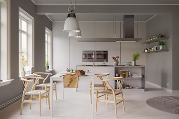 Phòng ăn màu xám này lại được thắp sáng nhờ bộ ghế gỗ Wishbone với những đường cong, một phong cách mang tính biểu tượng của nhà thiết kế đồ nội thất Hans Wegner người Đan Mạch.