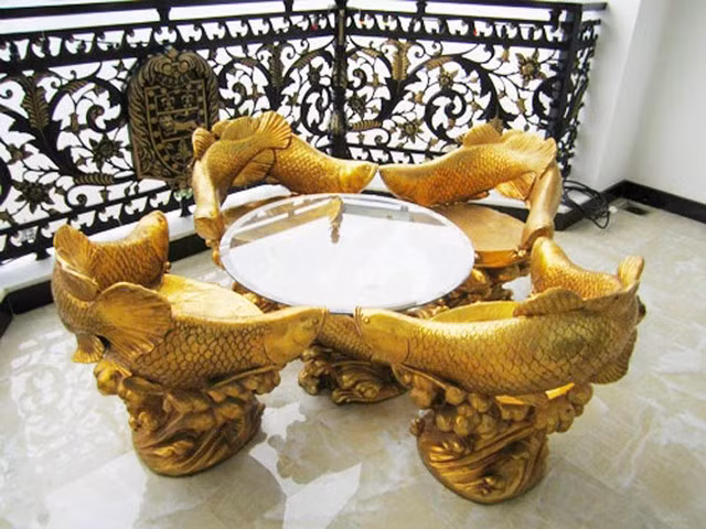 Bộ bàn ghế lạ mắt với hình cá chép được dát vàng thể hiện vẻ quyền quý.