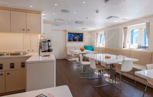 Khu vực phòng ăn và gian bếp nằm cạnh nhau, tất cả đều được trang bị nội thất màu trắng sang trọng.