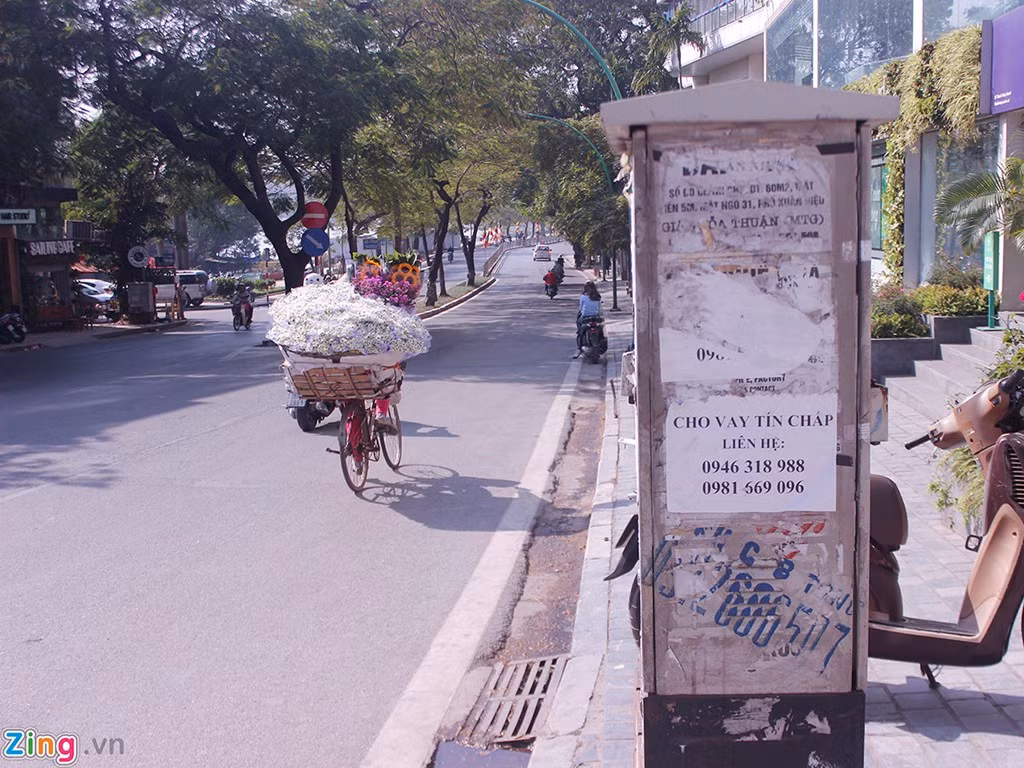 Đường Thanh Niên (quận Ba Đình, Hà Nội) vẫn giữ được nét thơ mộng của nó với những gánh hàng hoa nhưng chen lẫn đó là những thông báo “cho vay tín chấp” dán trên cột điện.