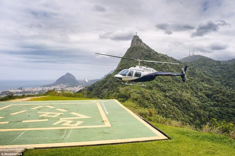 Một trực thăng ngắm cảnh chuẩn bị đáp xuống chân núi Corcovado ở Rio de Janeiro, Brazil. Bạn có thể thấy tượng Chúa Cứu Thế ở phía xa.