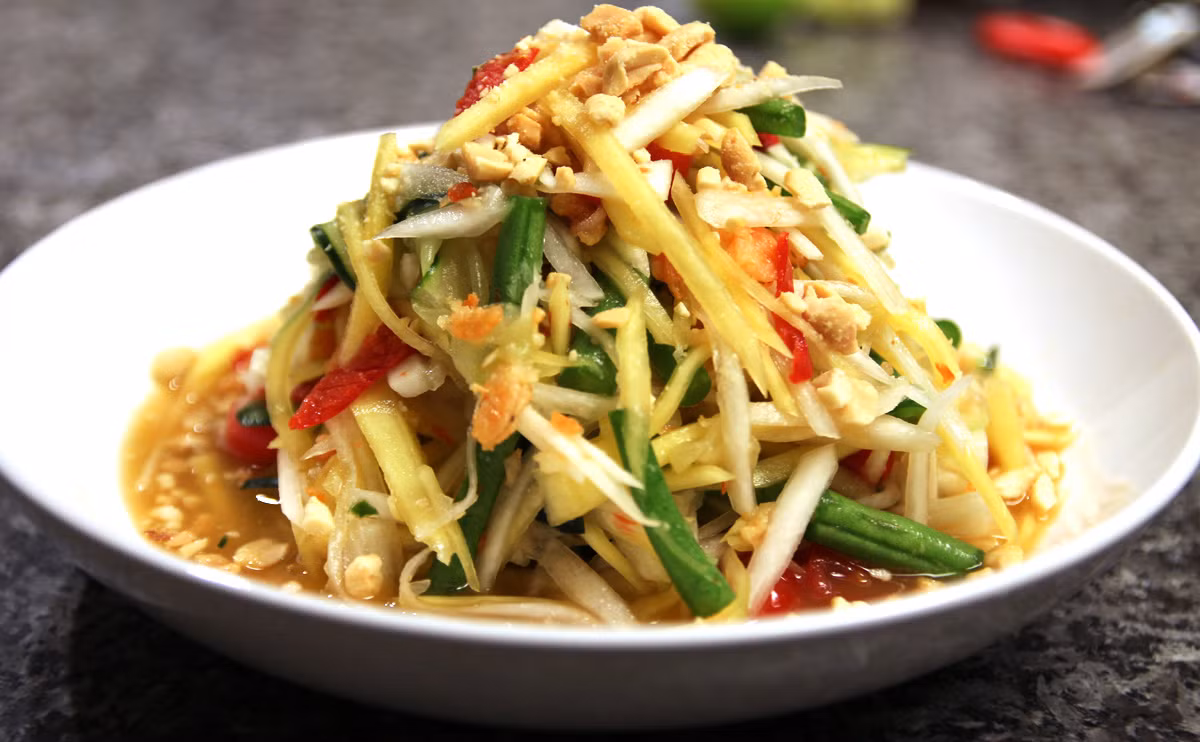 Nộm Somtam: Làm từ đu đủ thêm cà chua, đậu cắt nhỏ, nộm somtam là một trong những đồ ăn đường phố nổi tiếng nhất Thái Lan. Các nguyên liệu được cho vào cối giã sơ không bị nát nhưng thấm đều gia vị. Món ăn dễ làm nhưng ăn ngon miệng bởi đủ các vị chua cay. Tuy nhiên, nếu bạn bị đau dạ dày nên dặn chủ hàng cho bớt ớt.