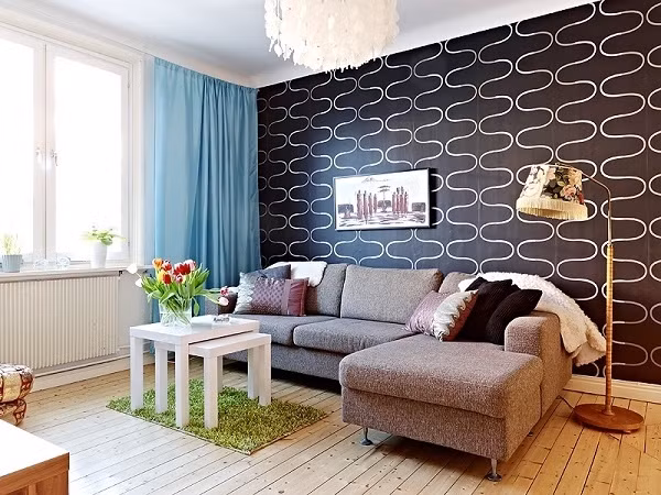 Việc kết hợp màu sắc một cách khéo léo luôn mang lại vẻ đẹp ấm áp, gần gũi cho không gian tiếp khách nhỏ xinh này. Gia chủ đã chọn giấy dán tường cho một bức tường vuông góc với cửa sổ vừa tạo độ sâu rộng vừa mang đến nét đẹp cá tính, ấn tượng cho căn phòng. Bên cạnh đó, những chi tiết khá nhỏ như đèn trần với ánh sáng vàng ấm áp kết hợp hài hòa với rèm cửa màu xanh da trời, thảm trải sàn màu xanh lá đủ để tạo nên nét đẹp đầy tinh tế và nghệ thuật cho không gian.