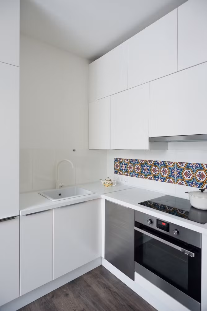 Bếp ăn với nội thất mang tông trắng. Màu trắng giúp không gian có cảm giác rộng hơn thực tế. Tuy nhiên, kiến trúc sư vẫn khéo léo sử dụng gạch hoa để tạo điểm nhấn cho căn bếp nhằm tách biệt không gian.
