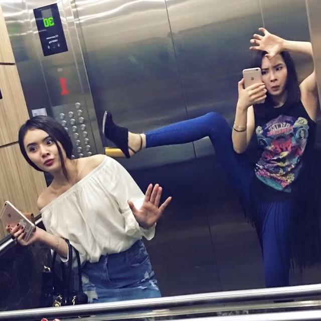 Cô đùa giỡn bên em gái trong thang máy.