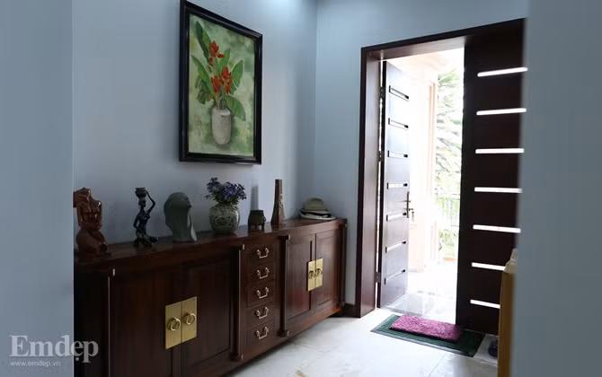 Lối vào nhà được thiết kế một kệ tủ dài để khách dừng chân, cất đồ.