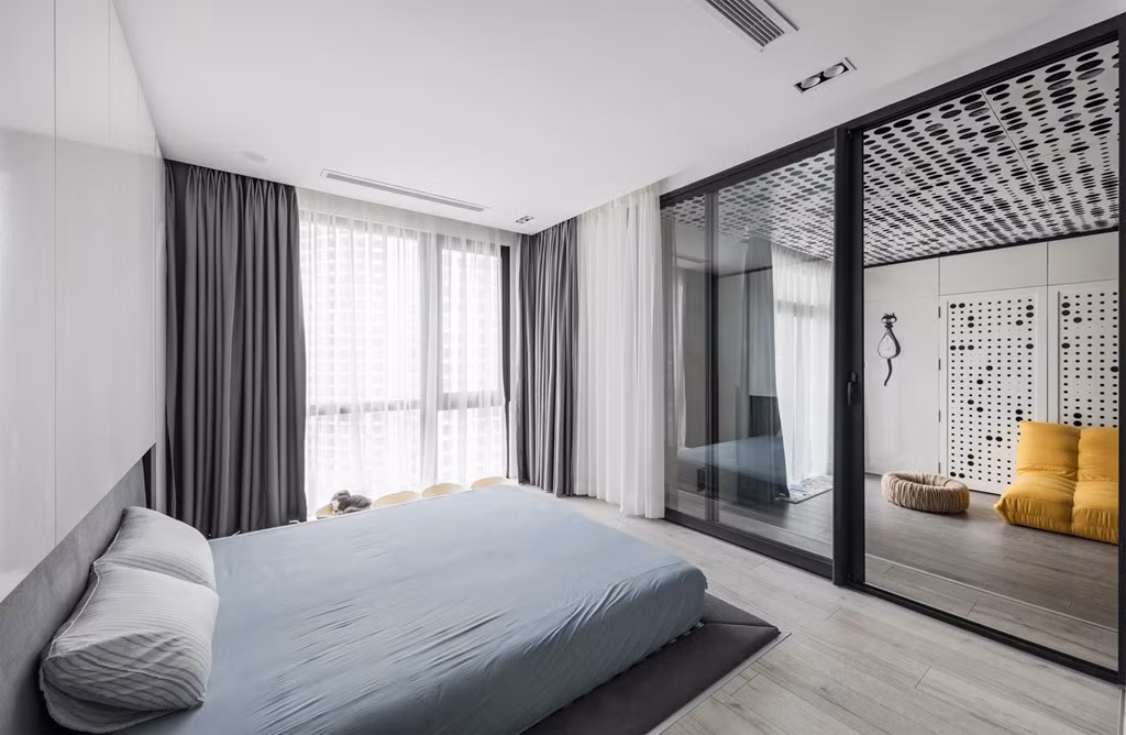 Phòng ngủ chính của căn hộ có cửa sổ lớn, giúp lấy sáng cho căn phòng và cho hai vợ chồng tầm nhìn rộng xuống quảng trường bên dưới.