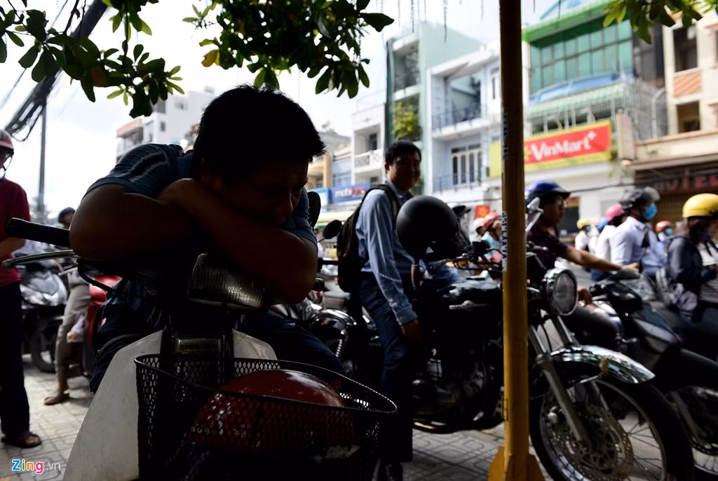 Một người tranh thủ chợp mắt dưới bóng cây bên vỉa hè trên đường Phan Văn Trị.