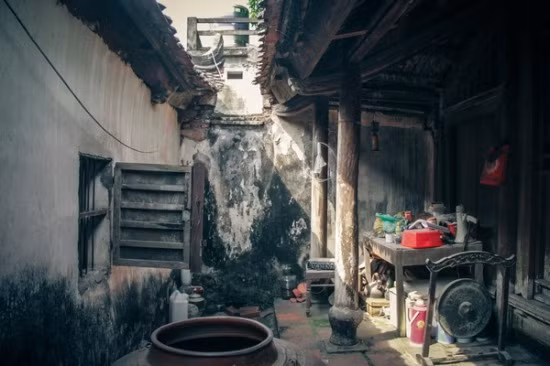 Một không gian cổ của ngôi nhà với chum nước, cối đá, chiêng đồng cũng như các cột kèo loang lổ màu thời gian.