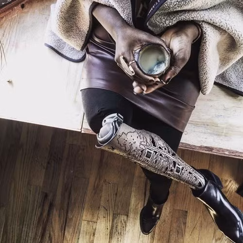 Mama Cax (sinh năm 1989 tại Brooklyn, Mỹ) nhưng lại lớn lên ở Montreal và Haiti. Từ năm 14 tuổi, Mama đã bị chẩn đoán mắc bệnh ung thư và không thể sống quá 3 tuần.