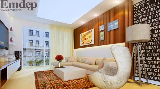 Đối diện bộ sofa là kệ gỗ đặt những bức tranh gia đình tạo nên không gian ấm áp, gắn kết các thành viên. Ti vi lớn treo tường giúp tiết kiệm diện tích để phòng khách trông rộng rãi và thoáng hơn.