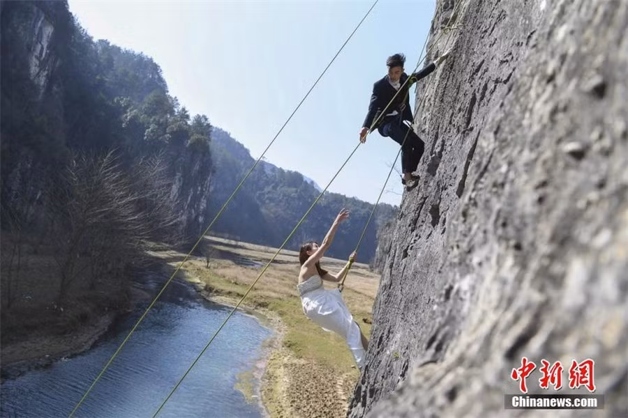 Vách đá cao 100 m bên bờ sông Tương Giang (tỉnh Hồ Nam, Trung Quốc) là nơi hai đôi uyên ương chọn tới chụp ảnh.