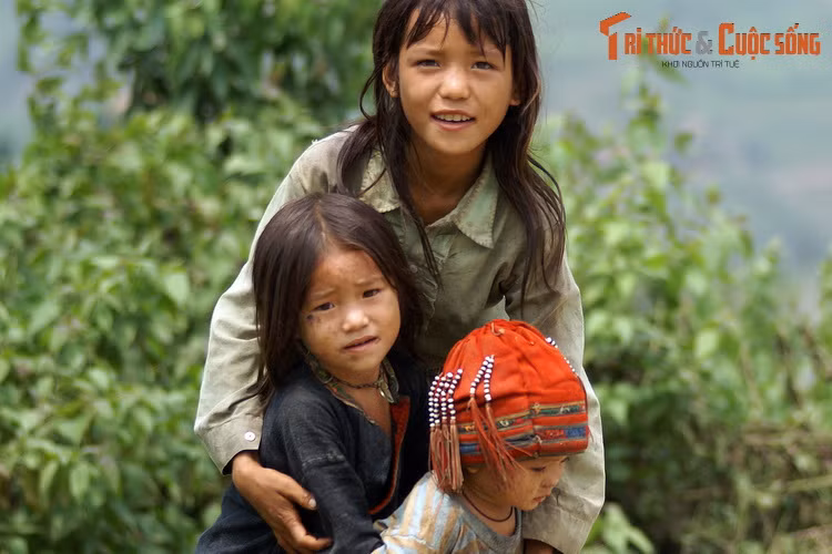Người chị chở che cho hai đứa em trước ánh nhìn của những vị khách phương xa.