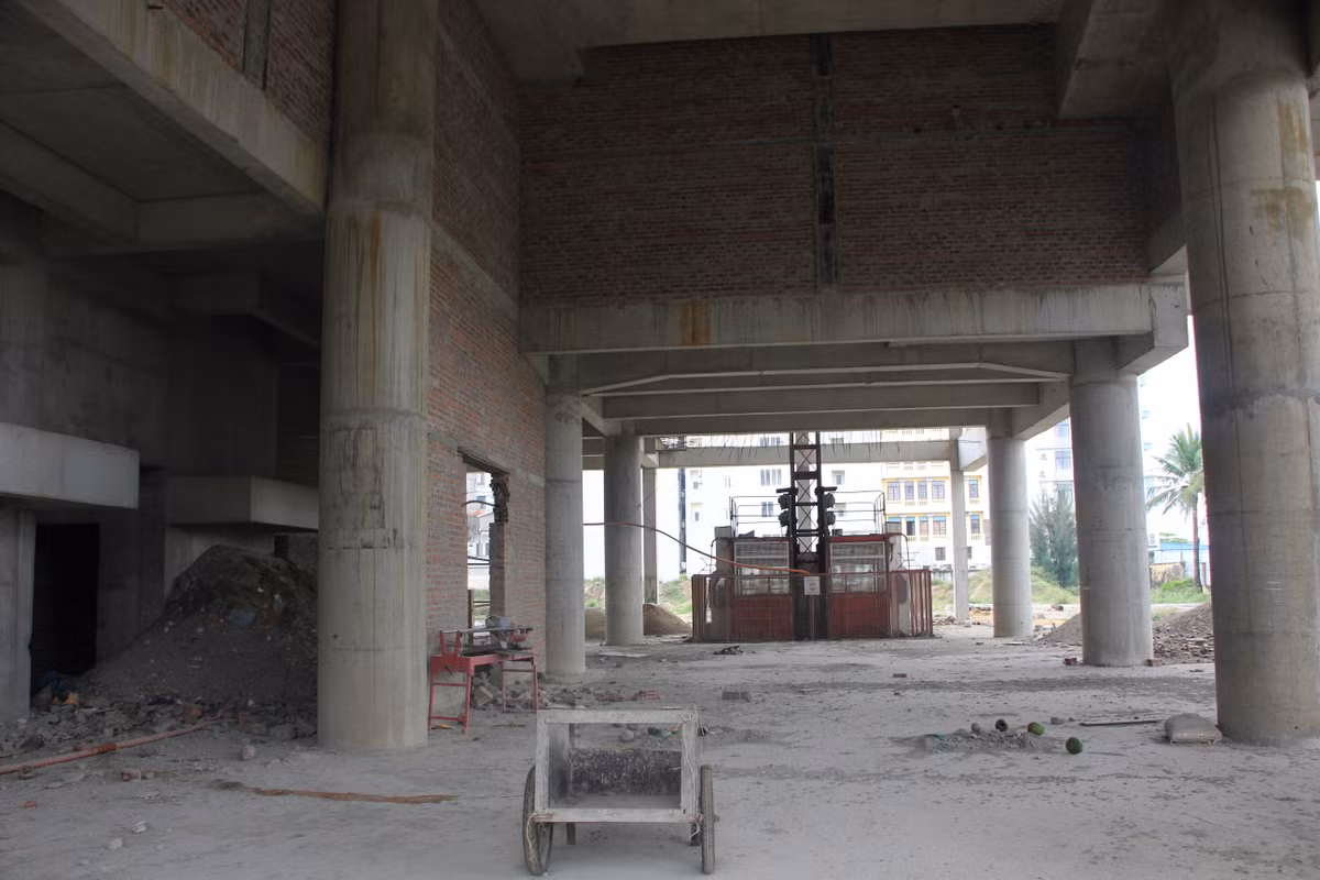 Công trình khách sạn đã được quây tôn kín bên ngoài. Phía trong là hạng mục thô chưa được hoàn thiện. Vật liệu xây dựng và thiết bị vẫn nằm ngổn ngang chưa thấy dấu hiệu thi công trở lại.