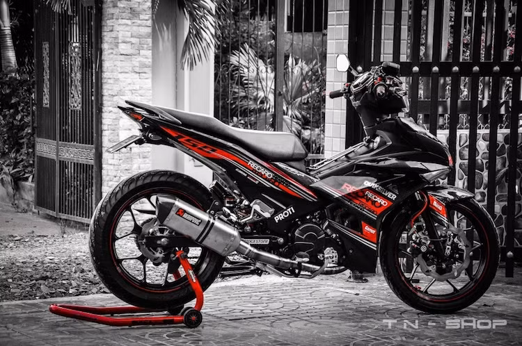 Với các đồ chơi "hàng hiệu, chiếc xe côn tay Yamaha Exciter 150 độ kiểng của một biker miền Tây đã trở nên đầy hấp dẫn và thể thao, đặc biệt khi chủ xe đã chọn cho nó "dàn áo" với tem màu đỏ - đen đơn giản nhưng đẹp mắ và đầy cuốn hút.