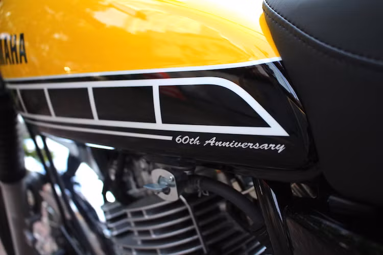 Ở cuối bình xăng, Yamaha cũng không quên đề dòng chữ 60th Anniversary để khẳng định sự đặc biệt của phiên bản này, cũng như "mừng sinh nhật" cho chính mình. Đặc biệt, bộ tem này là tem nước, được dán vào khi xe đã lên màu và sau đó phủ sơn bóng lên, khiến nó có được độ bền "trường tồn" cùng lớp sơn bóng bên ngoài xe.