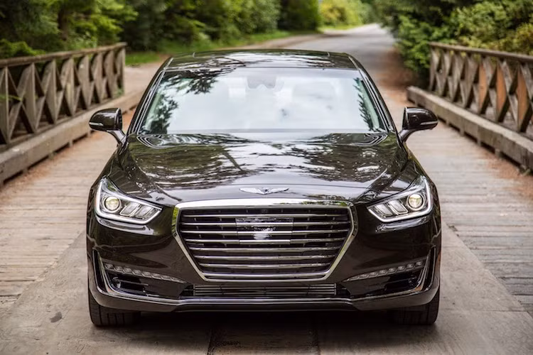 So với phiên bản Hàn Quốc, Genesis G90 2017 "bản Mỹ" vẫn sở hữu thiết kế lộ đầy vẻ sang trọng và uy nghi. Chiếm trọn mặt trước của xe là lưới tản nhiệt đặc trưng của Genesis mang tên Crest, kèm theo cặp đèn pha LED ban ngày lung linh như đá quý. Trên phiên bản V8, khách hàng còn có đèn full LED với hình dáng độc đáo.